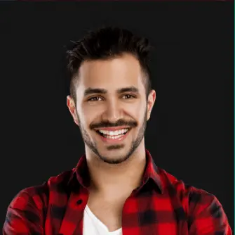 digital marketing company in kuwait-"Smiling man in a red and black checkered shirt with a white t-shirt underneath, standing against a dark background.